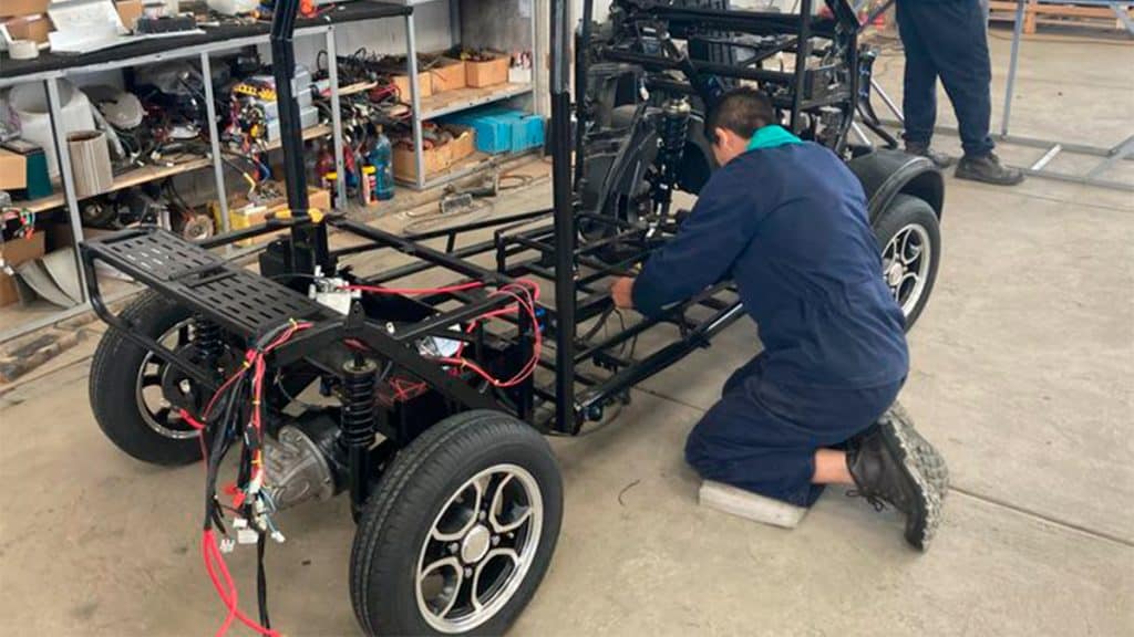 Funcionário montando minicarro elétrico boliviano