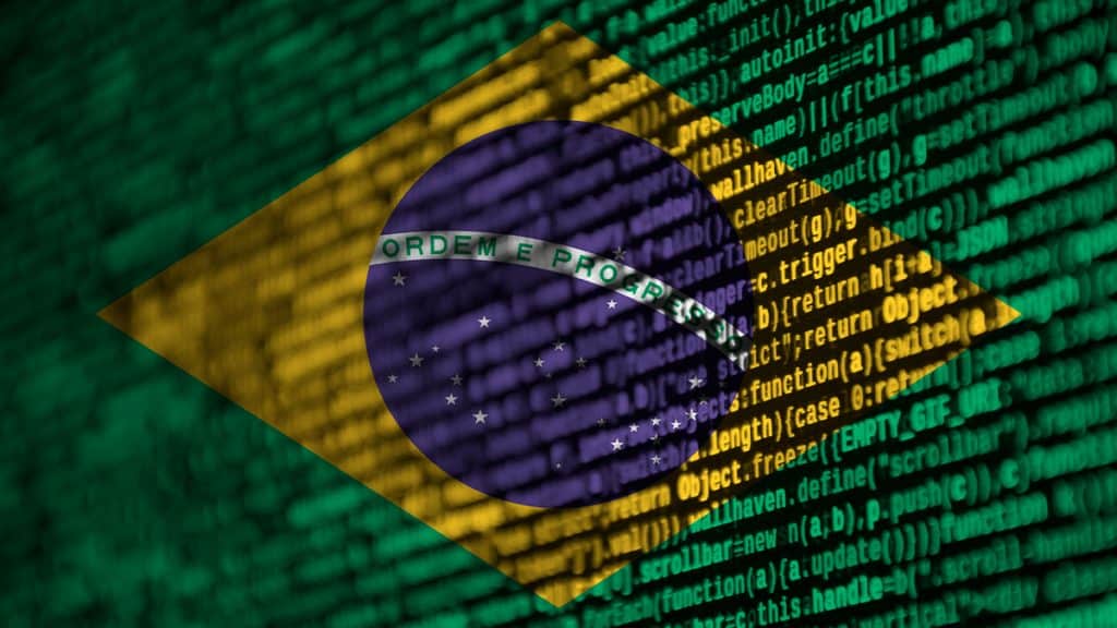 Montagem misturando bandeira do Brasil com linhas de código de programação para ilustrar conceito de cibersegurança no país