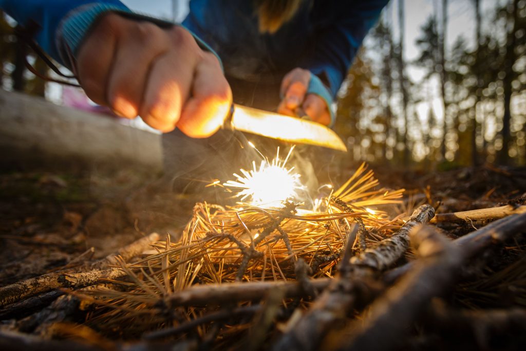 Imagem de homem fazendo fogo na natureza