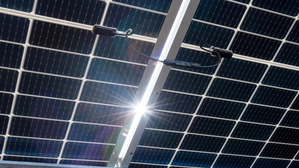 Painéis solares bilaterais, fotovoltaicos? com brilho natural do sol - fonte alternativa de eletricidade, conceito de recursos sustentáveis e renováveis. Vista panorâmica para trás.
