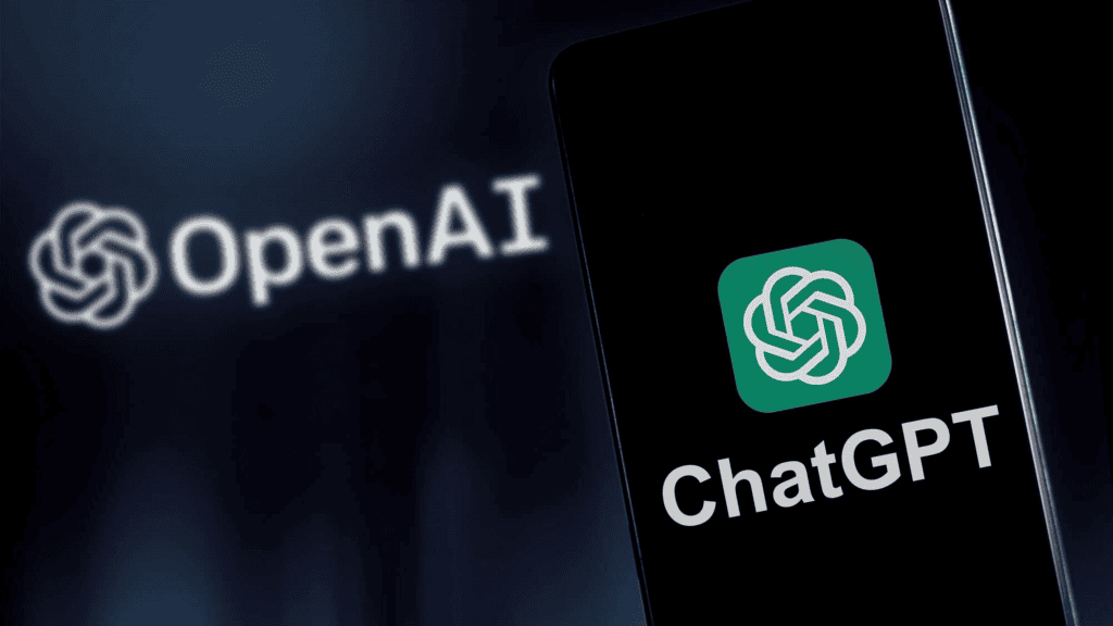 Aplicativo do ChatGPT sendo aberto em um celular e no fundo o logo da Open AI, empresa que desenvolveu a ferramenta